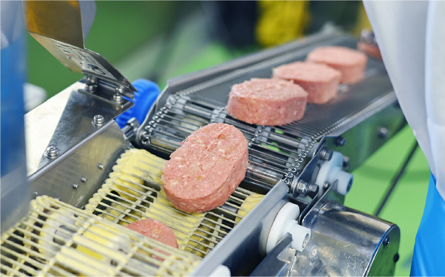 ミンチのハンバーグを機械が運んでいる写真