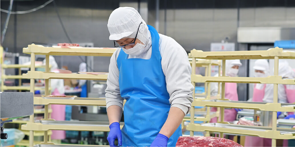 社員の男性が手作業で肉を製造している写真