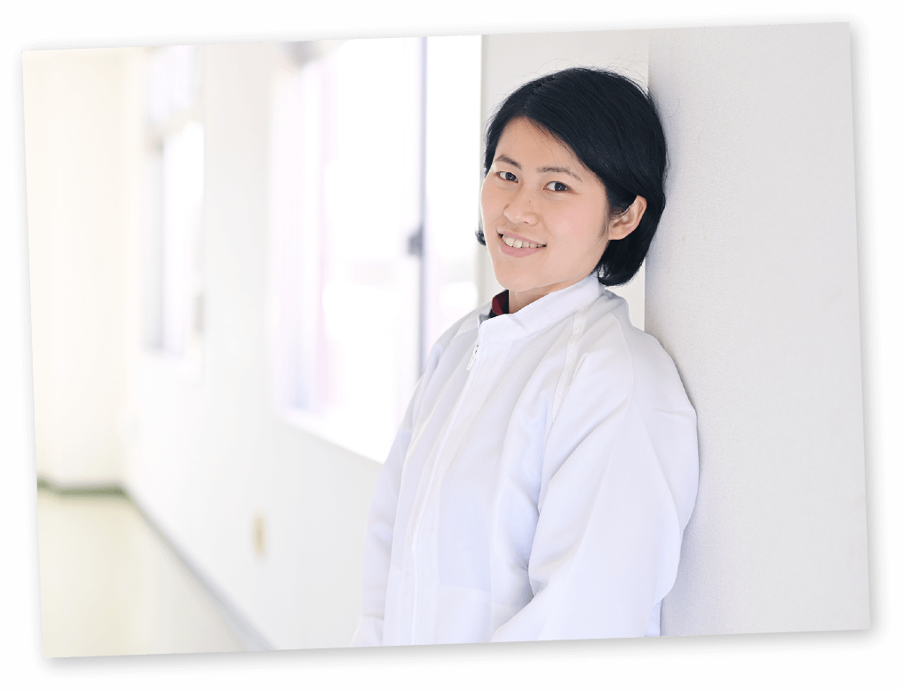 壁にもたれかかり笑顔のH・Tさん