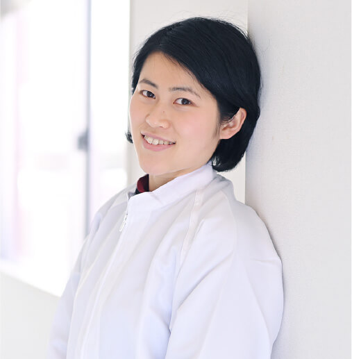 壁にもたれかかり笑顔のH・Tさん