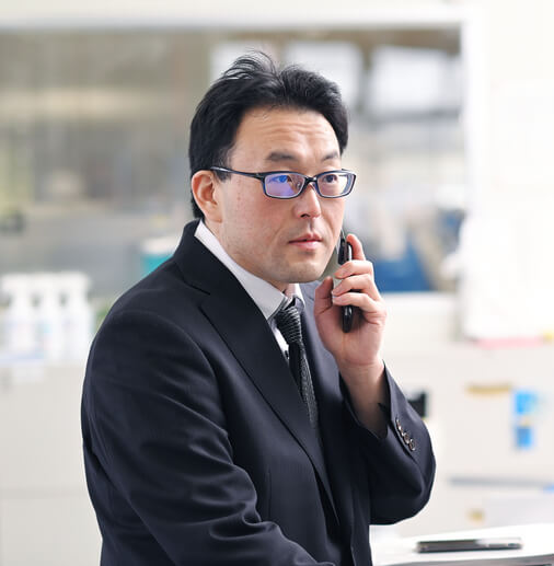 パソコンの前で電話をするM・Tさん